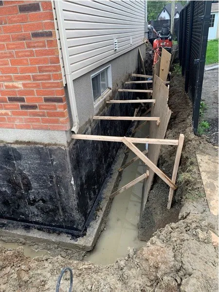 Préparation du mur de solage pour l’installation d’une membrane d’étanchéité  à Longueuil.